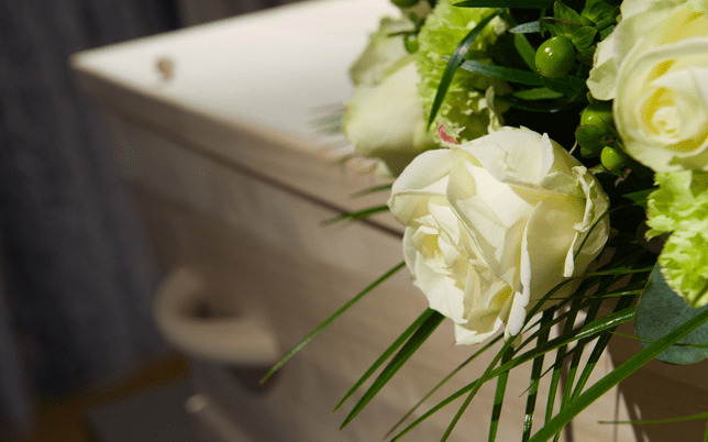 Coffin with a white rose flower